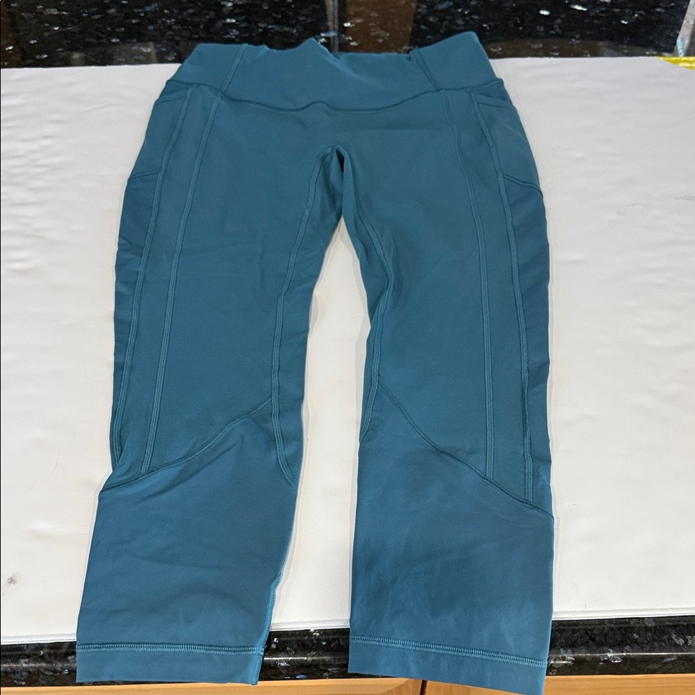 Size 10 Lululemon teal leggings with side pocket. Ankle length.